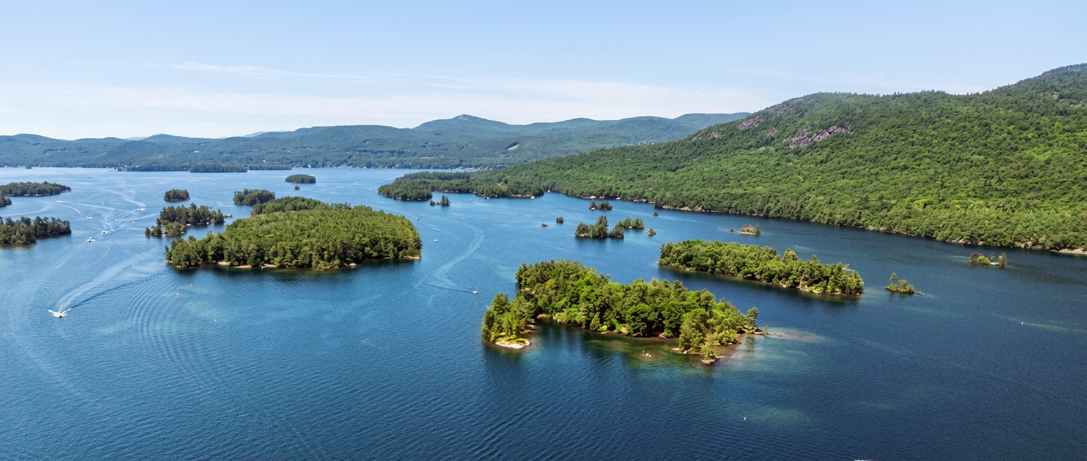 Aerial view of Lake George, New York, with forested islands and Adirondack mountains